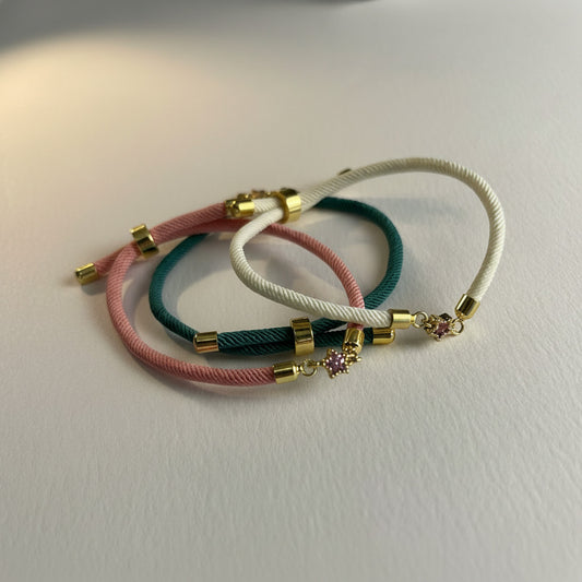 Three colorful rope friendship sliding bracelets with gold gem stars on a white background