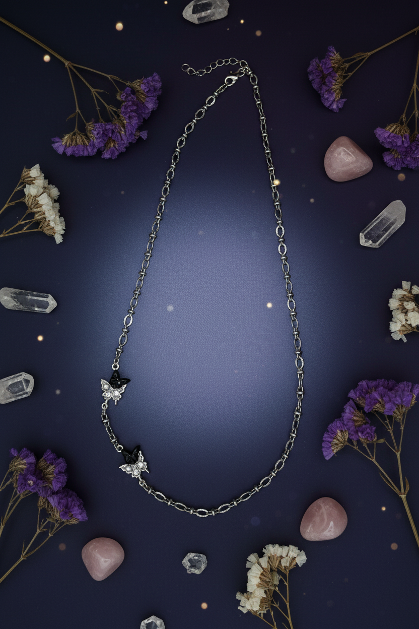 Silver necklace with star and butterfly pendants on a light gray background