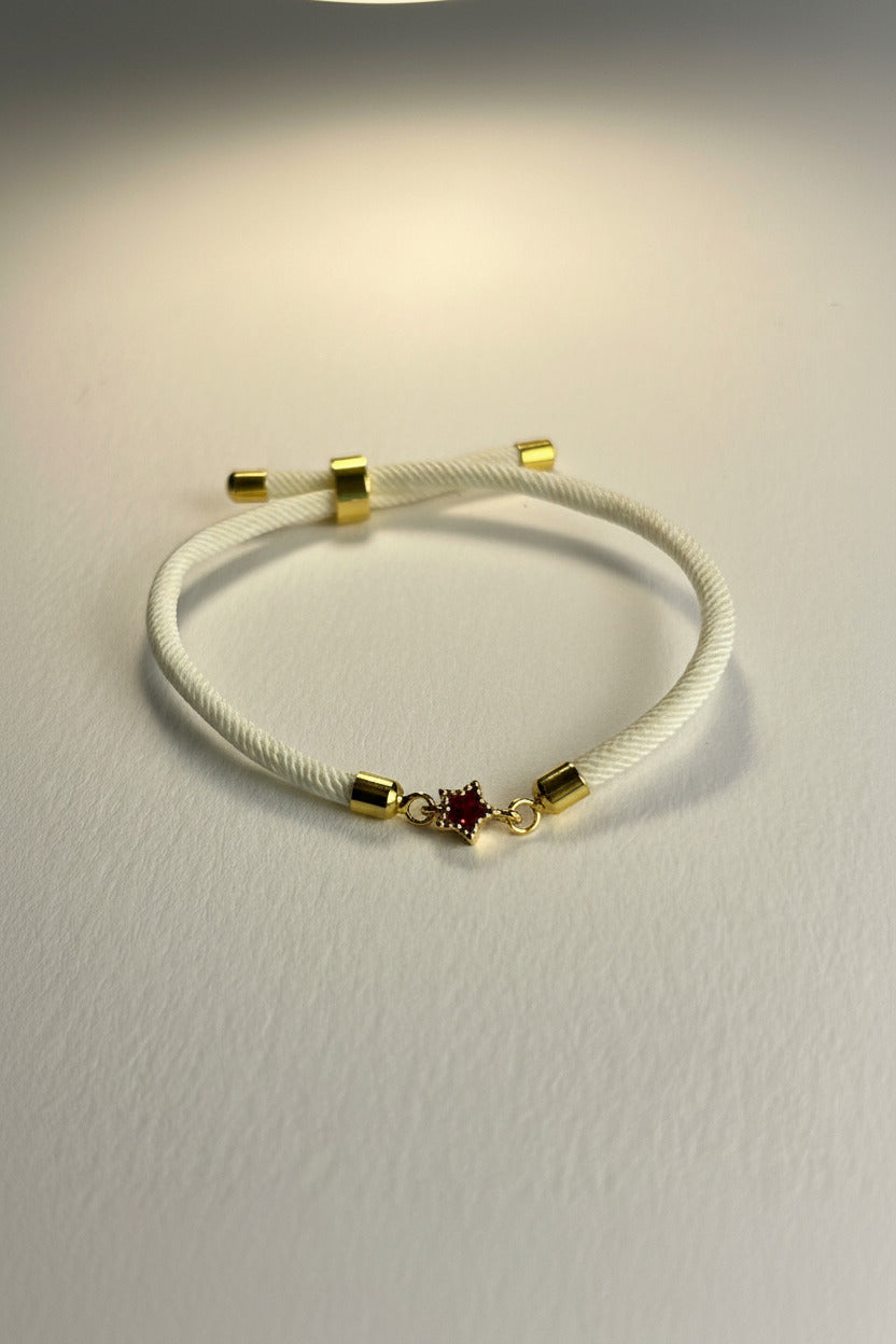 White bracelet with gold accents on a light gray background